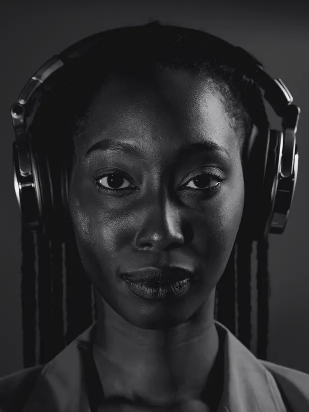 Retrato em preto e branco de uma mulher com tranças e fones de ouvido
